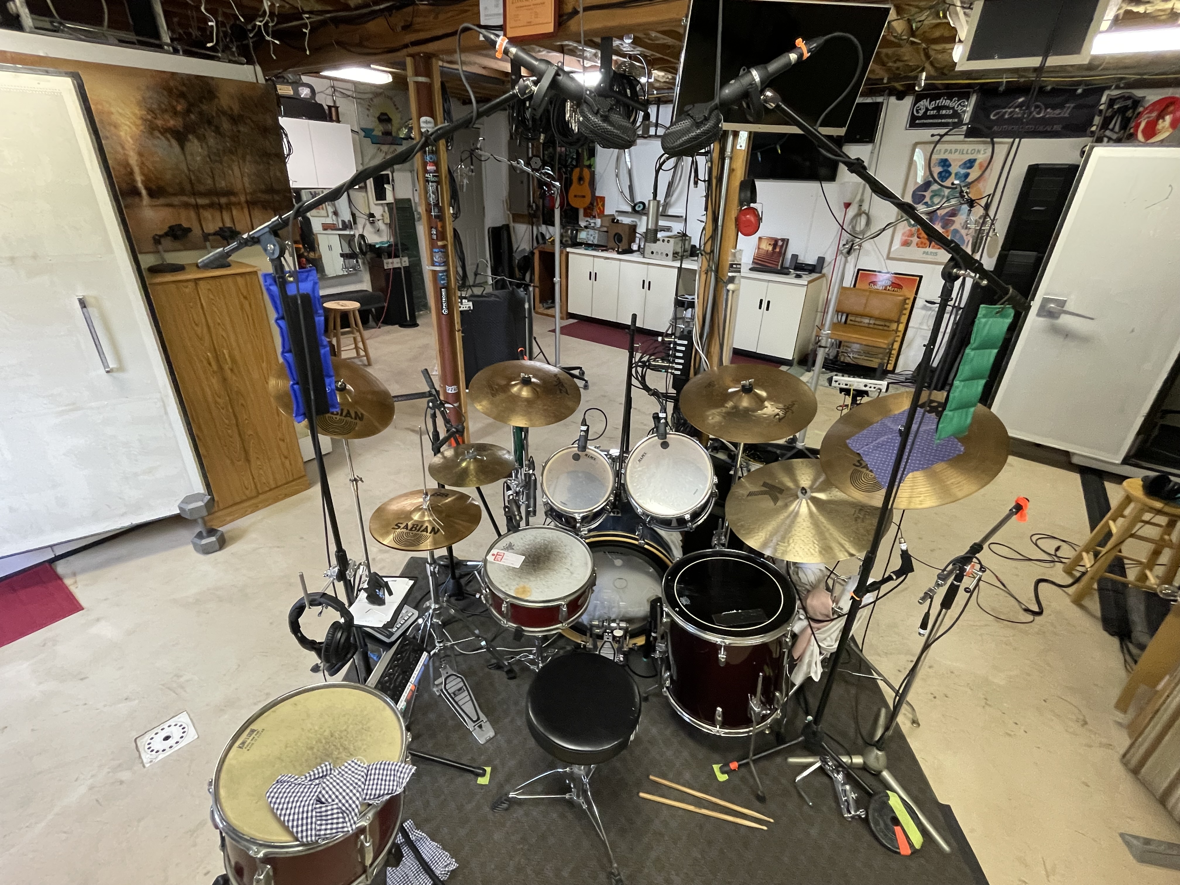 Full acoustic drum kit set up in the studio live room, with microphones positioned on each drum