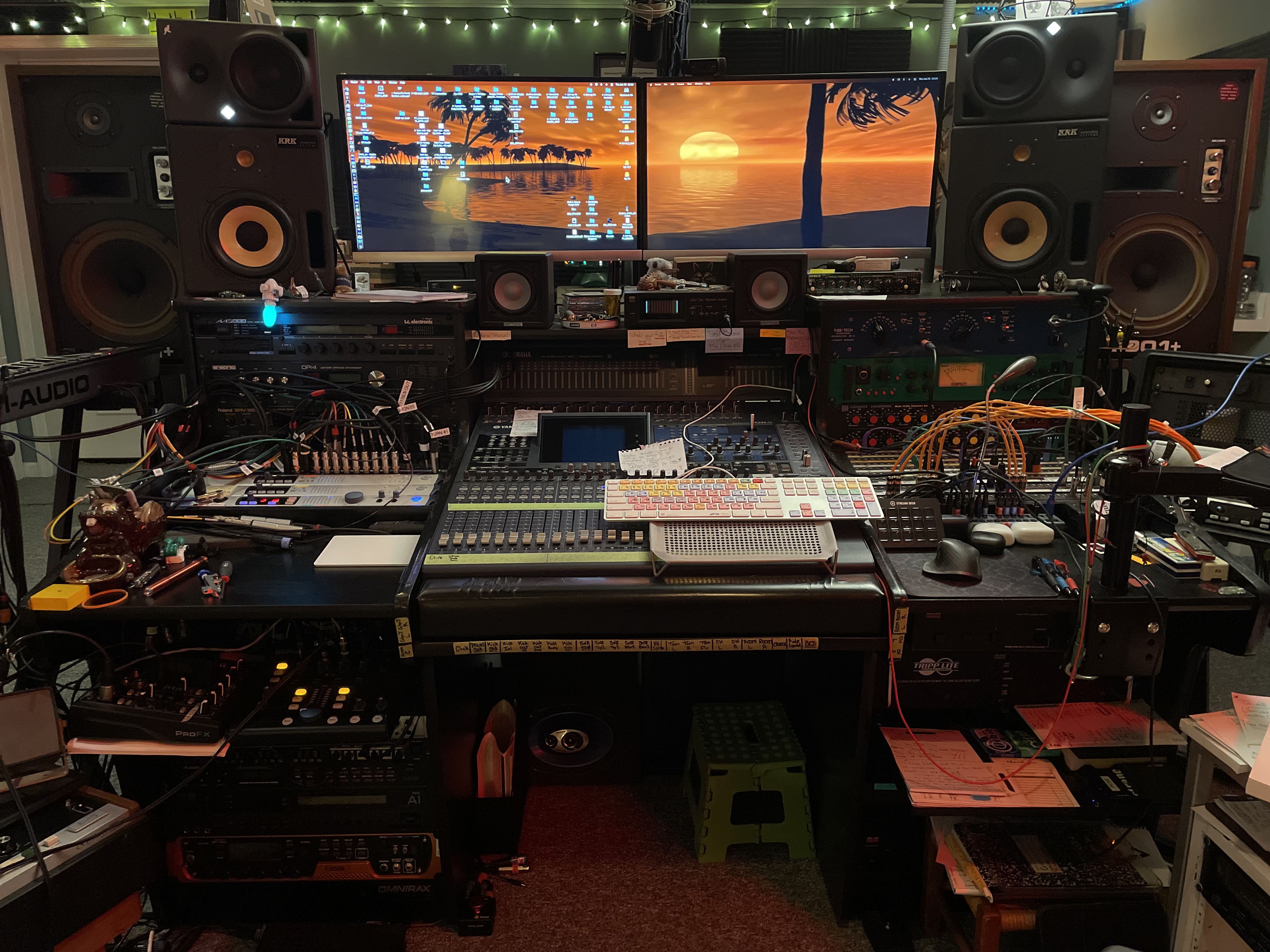 Studio desk setup with dual monitors, Pro Tools session displayed, and Yamaha 02R96 console in the background